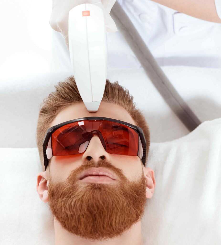 young man receiving laser skin care on face. healthy lifestyle man concept